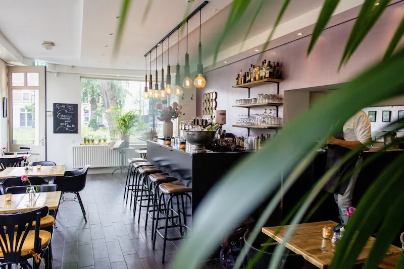 plano-interior-cafe-sillas-cerca-bar-mesas-madera